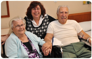 Couple in wheelchairs with woman