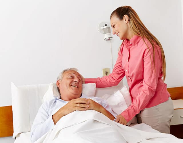 inpatient Woman Comforting Smiling Patient in Hospital Bed