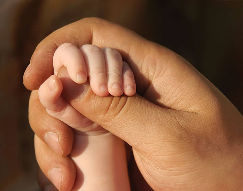 fundación Primer plano de un padre sosteniendo la mano de su bebé