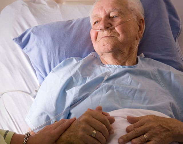 make_difference Una paciente en la cama de un hospital tomado de la mano con una mujer