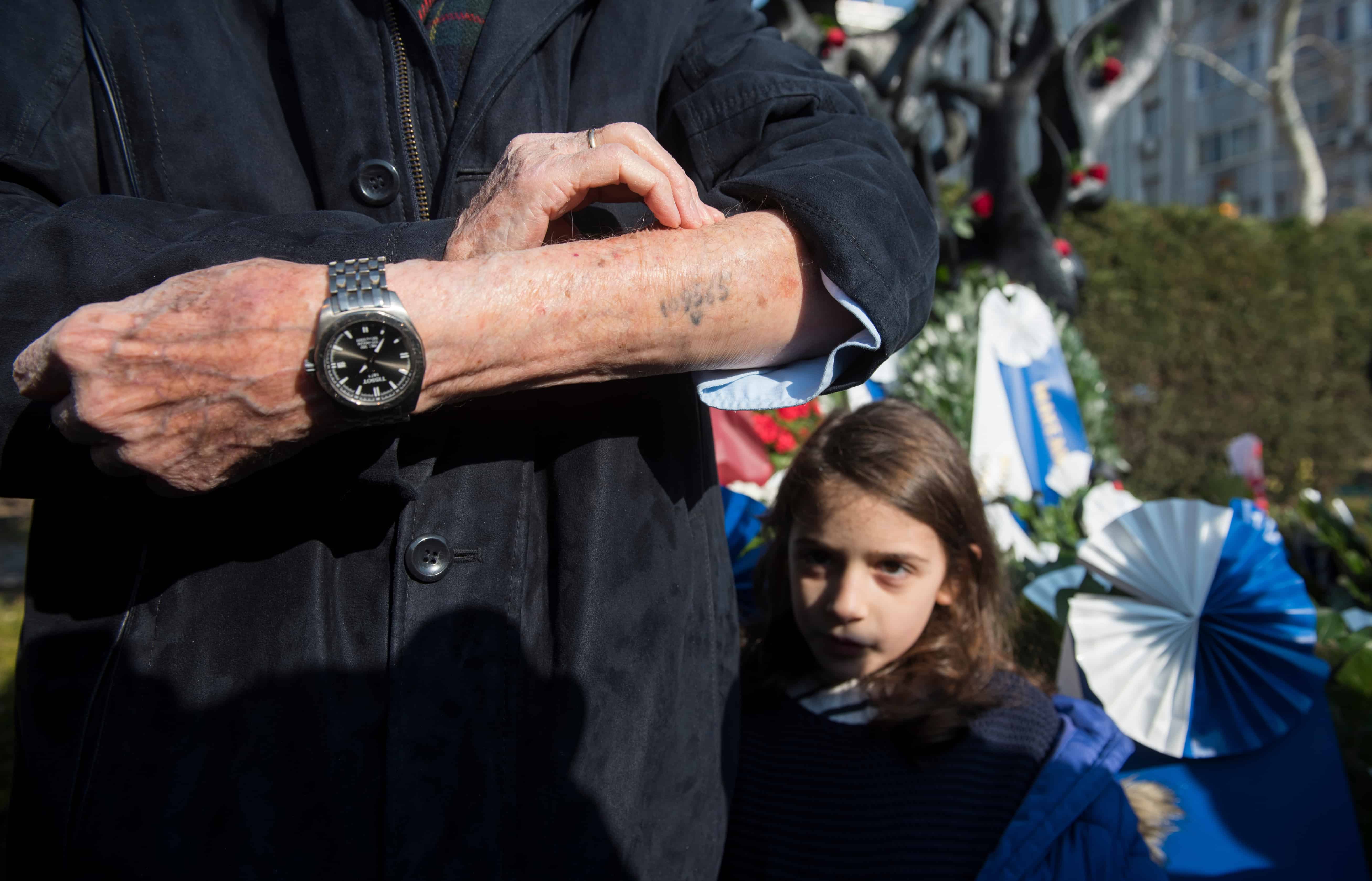 Navigating Through the Pain.Holocaust Elderly Man Rolling Up Sleeve to Show Tattoo