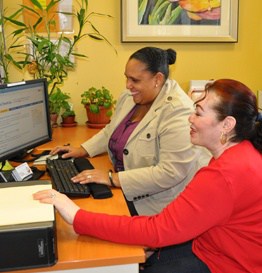 CommunityCenter_SeniorResourceCenter Two Women Smile and Look at a Computer Together