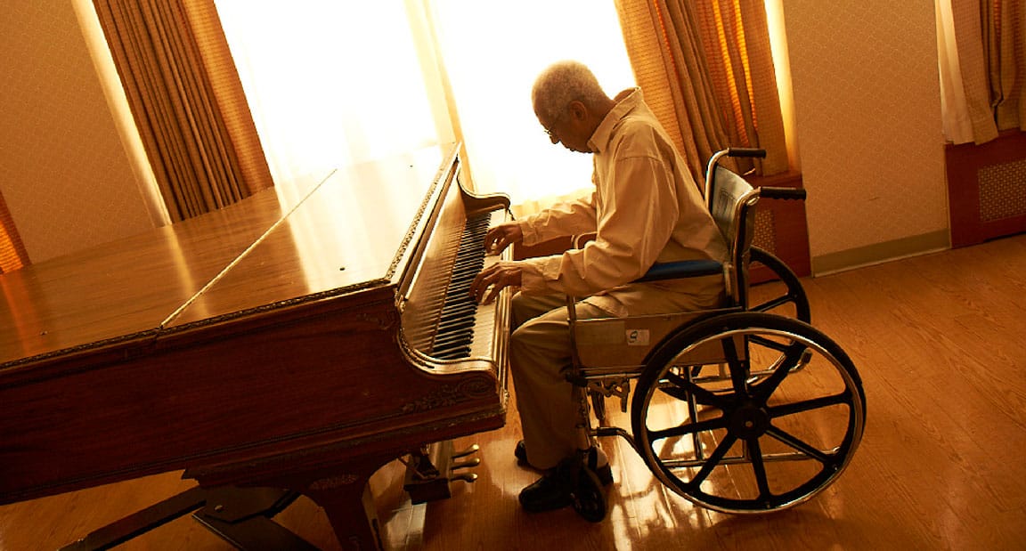 LongTermCare03 Long Term Elderly Man in a Wheelchair Plays the Piano
