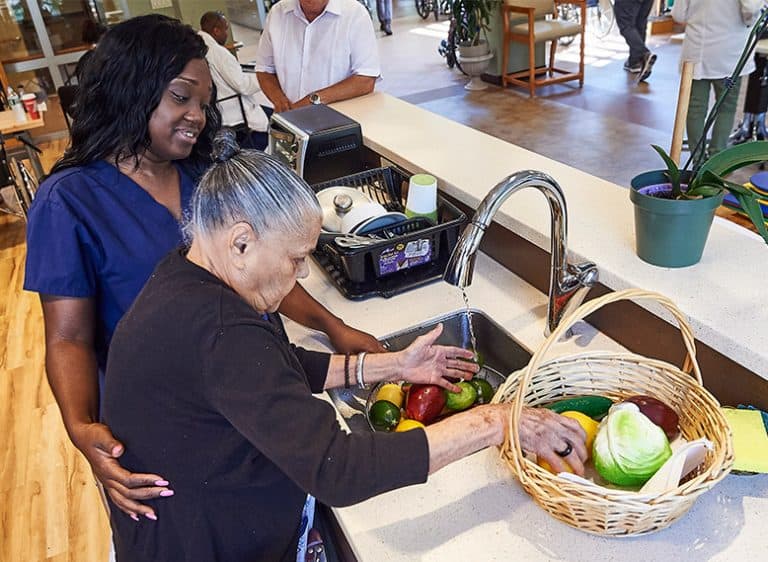 Short stay rehab at isabella center MJHS Caregiver Assists Elderly Patient Washing Vegetables