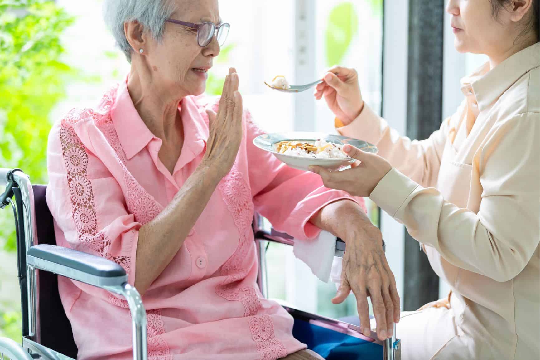 Woman in a wheel chair refusing to eat