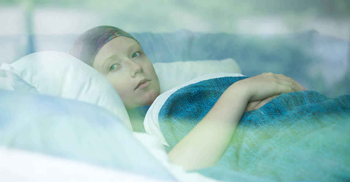 Young woman in bed suffering from cancer