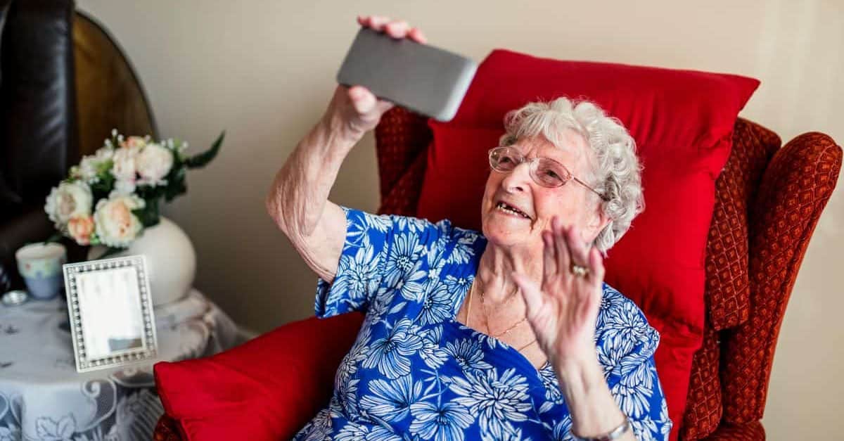 Adulto mayor hablando con el cuidador en una videollamada